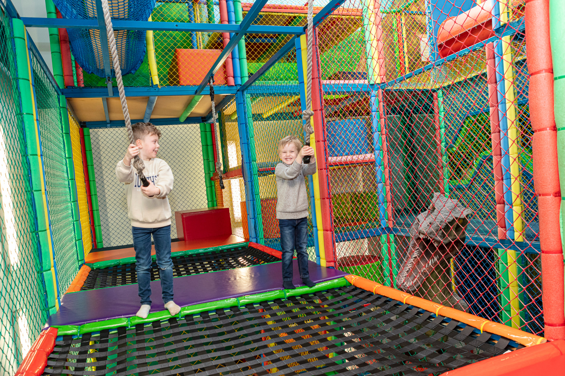 Children exploring the indoor soft play area at ROARR! Dinosaur Adventure, featuring climbing frames, slides, tunnels and colourful play equipment.