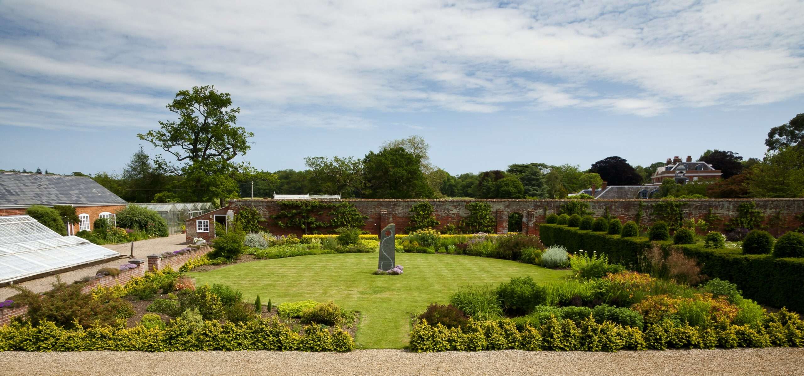 View across formal gardens and landscaped grounds from an elevated viewpoint.