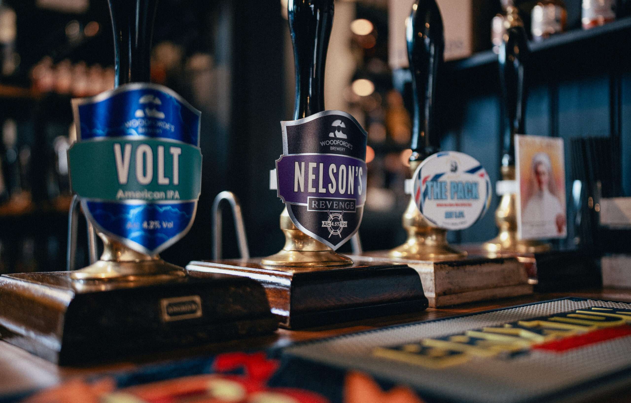 Selection of real ale hand pumps at The Green Dragon bar, including locally brewed beers and traditional cask ales.