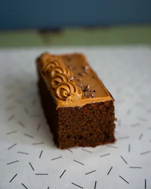Close-up of a freshly baked loaf cake with decorative icing and patterned topping.
