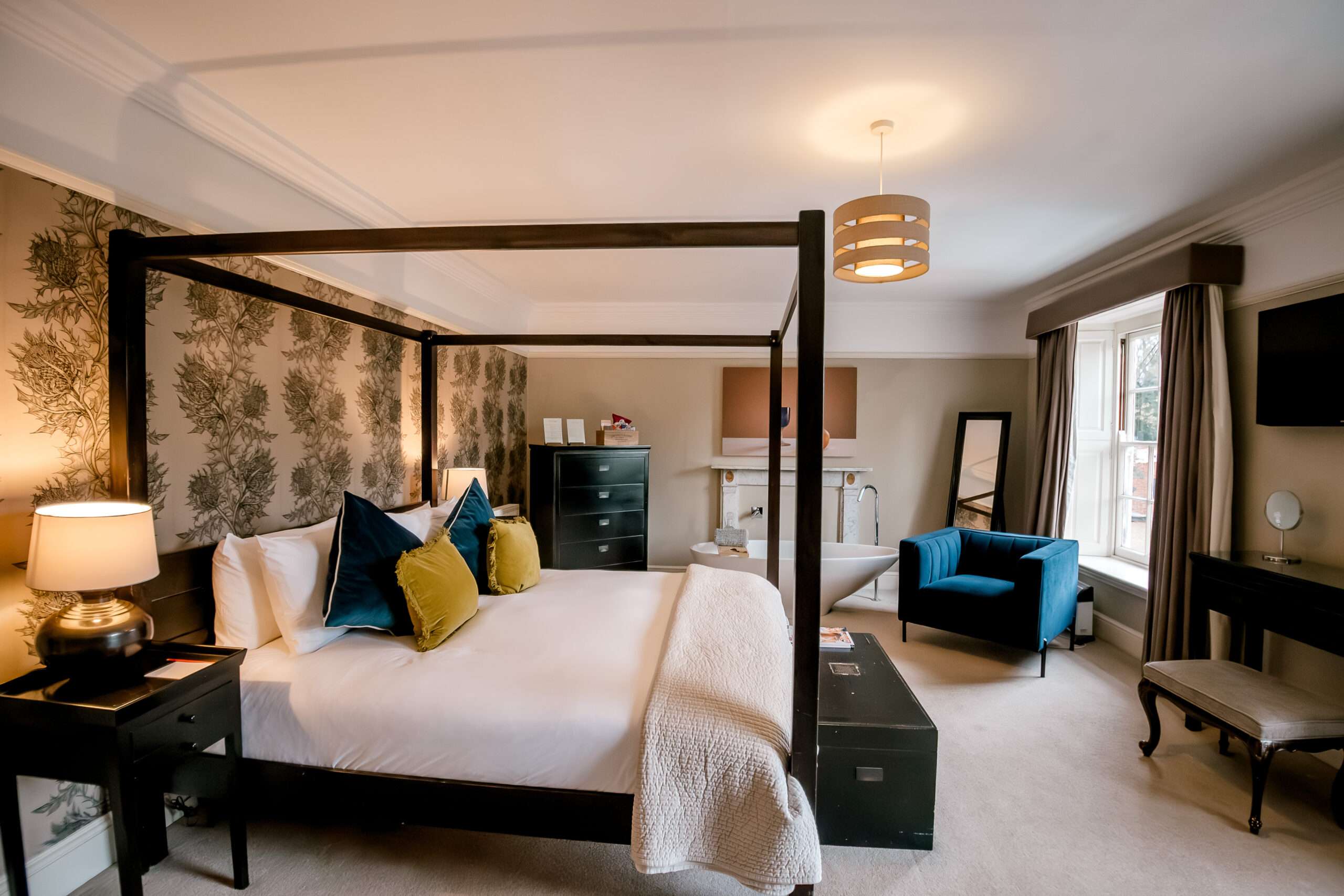 Elegant bedroom at Norfolk Mead Hotel featuring a four-poster bed and stylish furnishings.