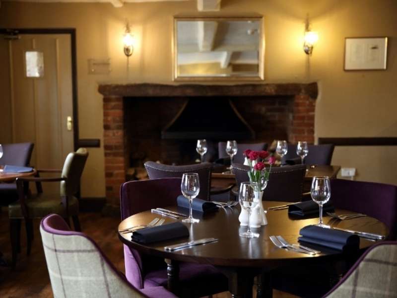 Cosy dining area at The Recruiting Sergeant with a traditional fireplace, comfortable seating and a welcoming pub setting.