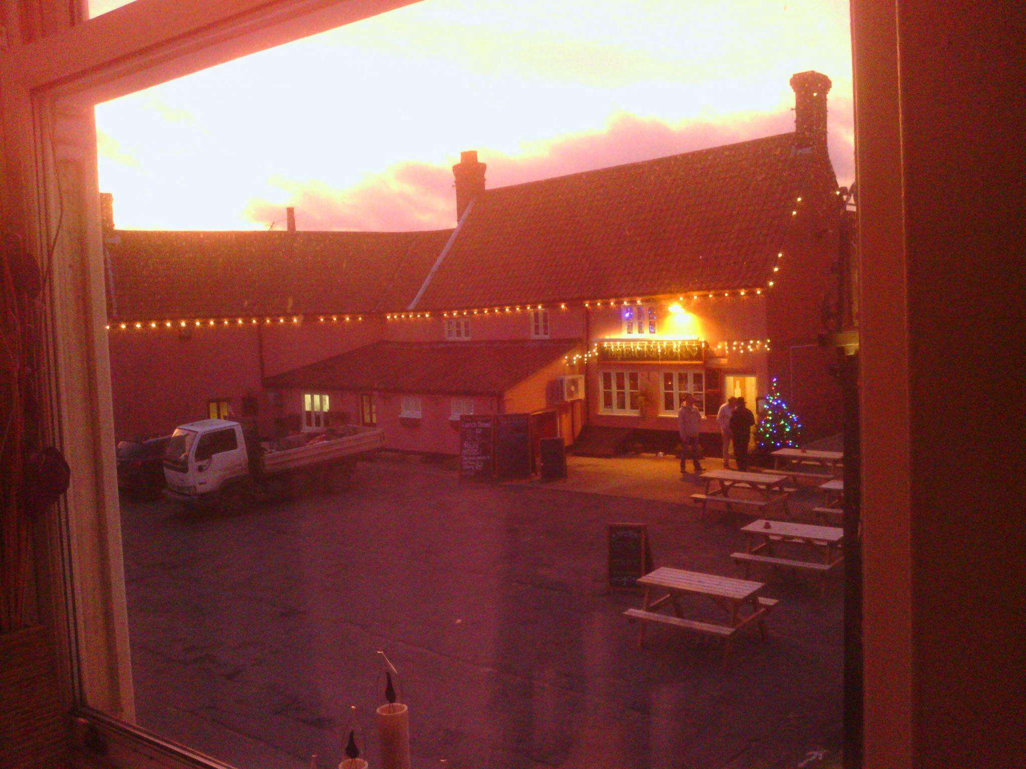 The Unicorn Aylsham at sunset, with outdoor seating and warm evening light creating a welcoming atmosphere.