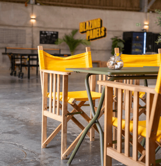 Seating area inside Blazing Padels at Salle Moor Farm, featuring tables, chairs and views of the indoor padel facility.