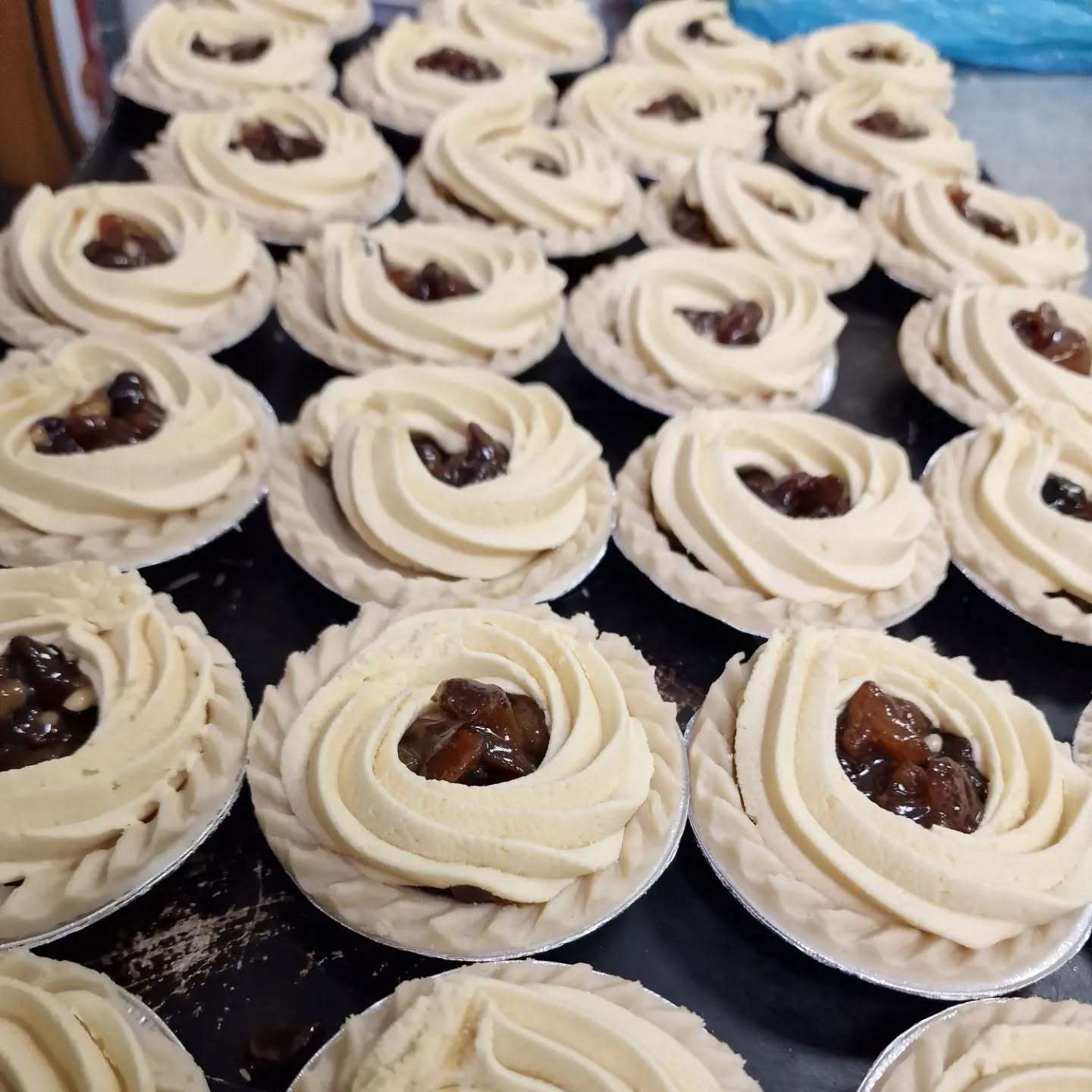 Freshly baked cinnamon swirls arranged on a bakery tray.