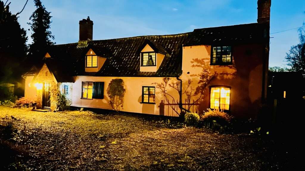 Danegelts accommodation illuminated at night with traditional Norfolk character.