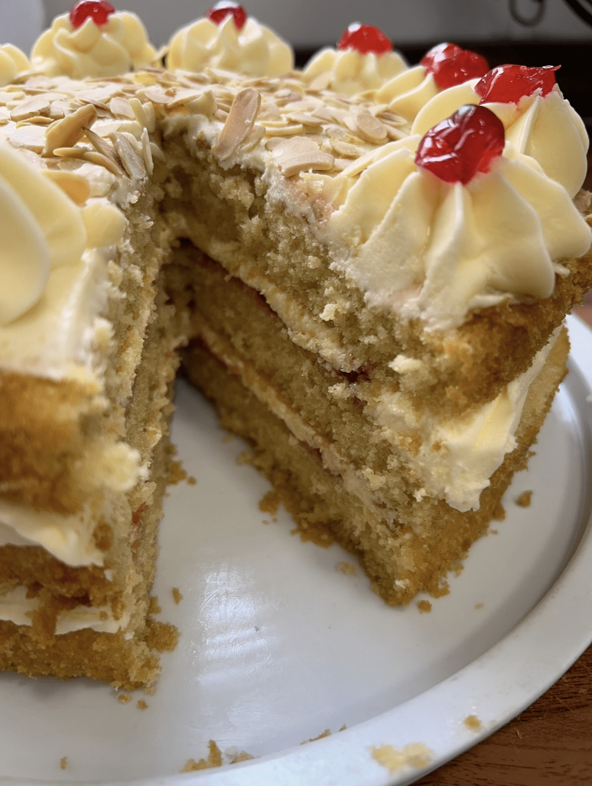 Slice of homemade sponge cake filled and topped with buttercream and fruit at A Piece of Cake café in Coltishall.