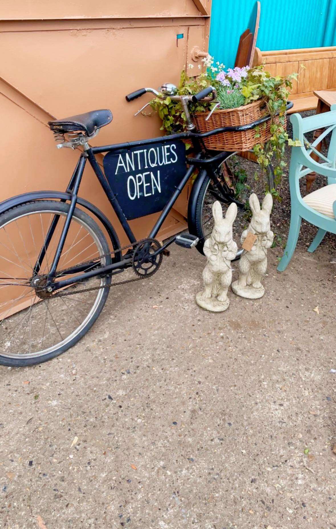 Decorative bicycle and antiques sign outside an independent antiques shop Williams and Parfitt Wymondham