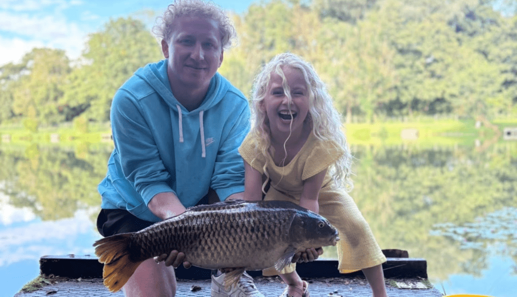 Two visitors beside a lakeside fishing platform at Barford Lakes.