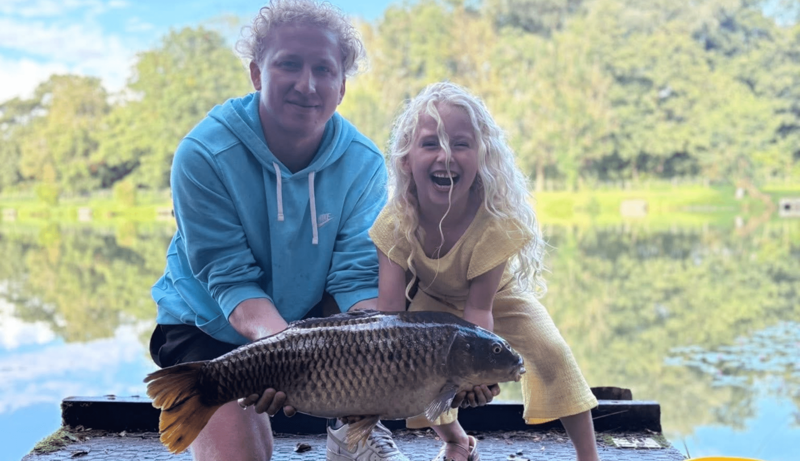 Two visitors beside a lakeside fishing platform at Barford Lakes.