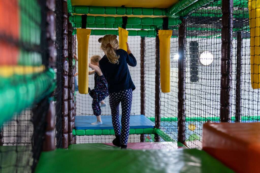 Children navigating padded obstacles and play equipment inside the Bananas Soft Play adventure zone.
