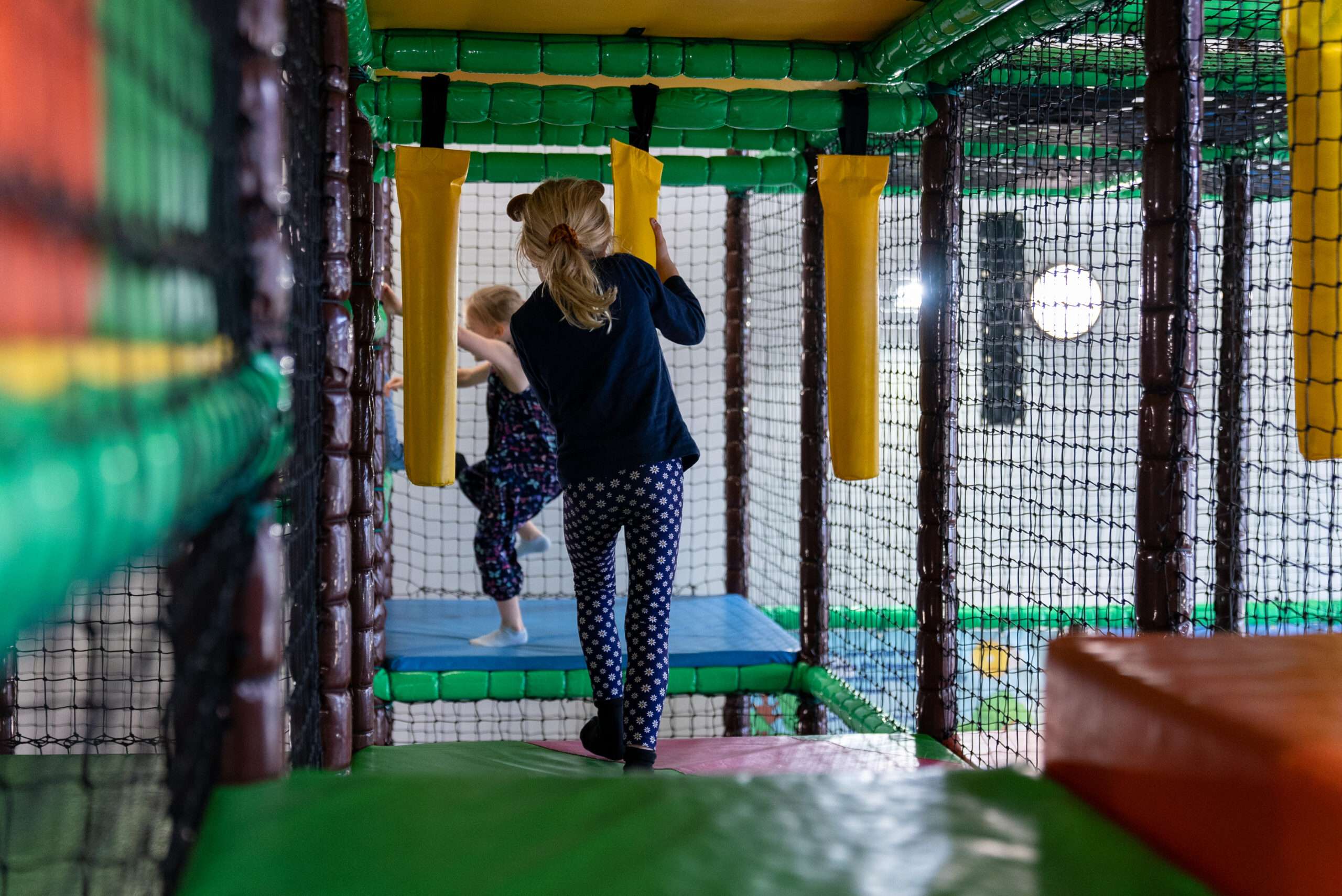 Children navigating padded obstacles and play equipment inside the Bananas Soft Play adventure zone.