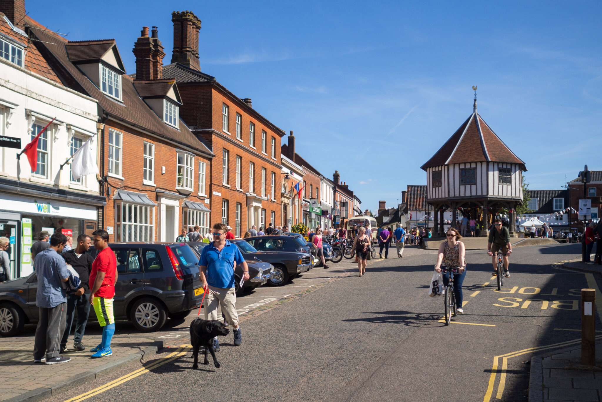 Historic Market Place in Wymondham with colourful Georgian buildings, the Market Cross and a wide town centre street scene.Provide your feedback on BizChat