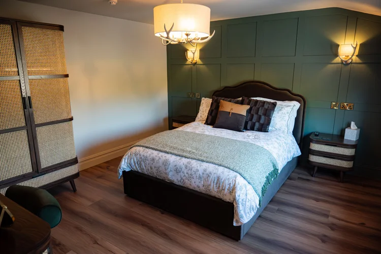 Comfortable guest bedroom at The Huntsman, Strumpshaw, featuring a double bed, bedside lighting, and stylish country-inspired décor.