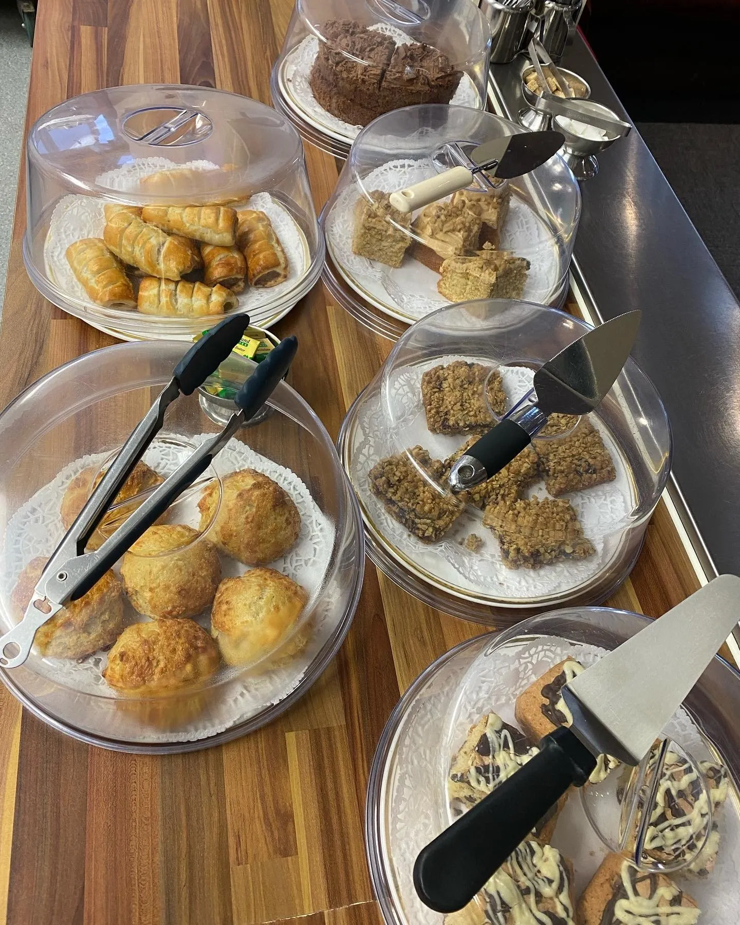 Selection of homemade cakes, flapjacks, biscuits and freshly baked savouries displayed on a serving table at Hug a Mug Café in Lingwood.